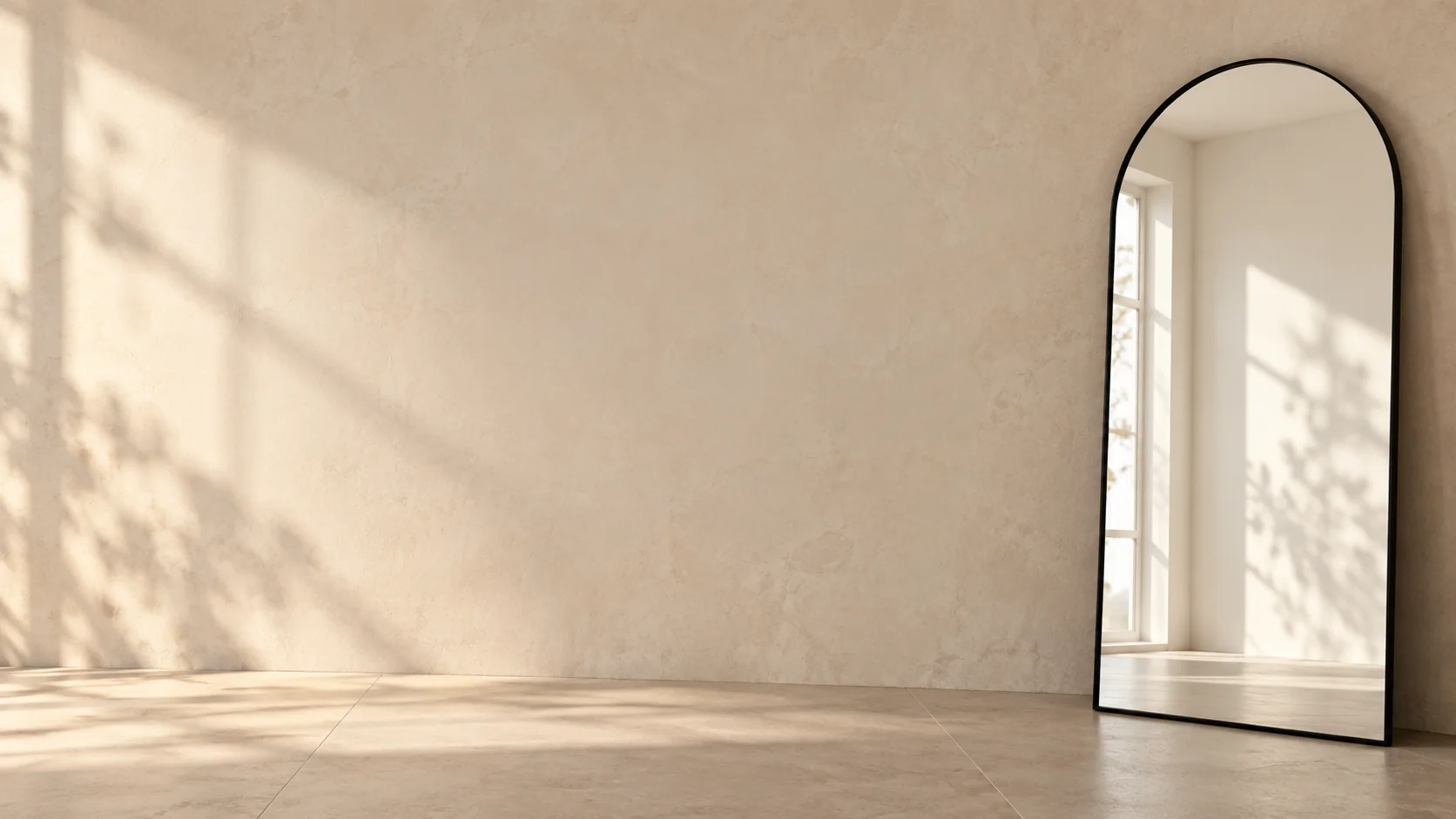 Grand miroir arche Ayachouf au cadre noir, adossé à un mur beige et reflétant une fenêtre