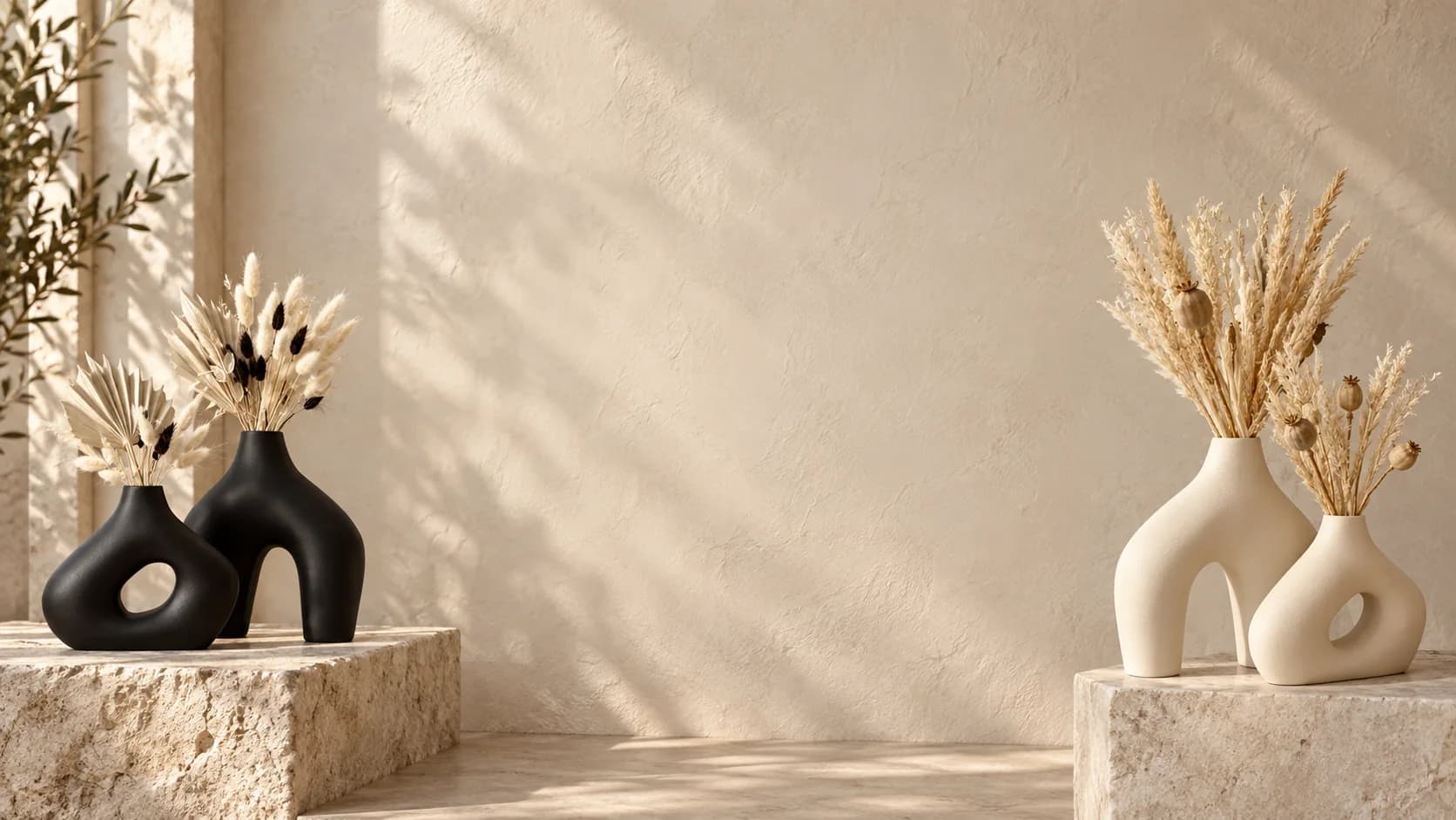 Vases Ayachouf noirs et crème garnis de fleurs séchées sur des blocs de travertin